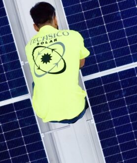 Techsico Solar technician installing panel racking on a rooftop array