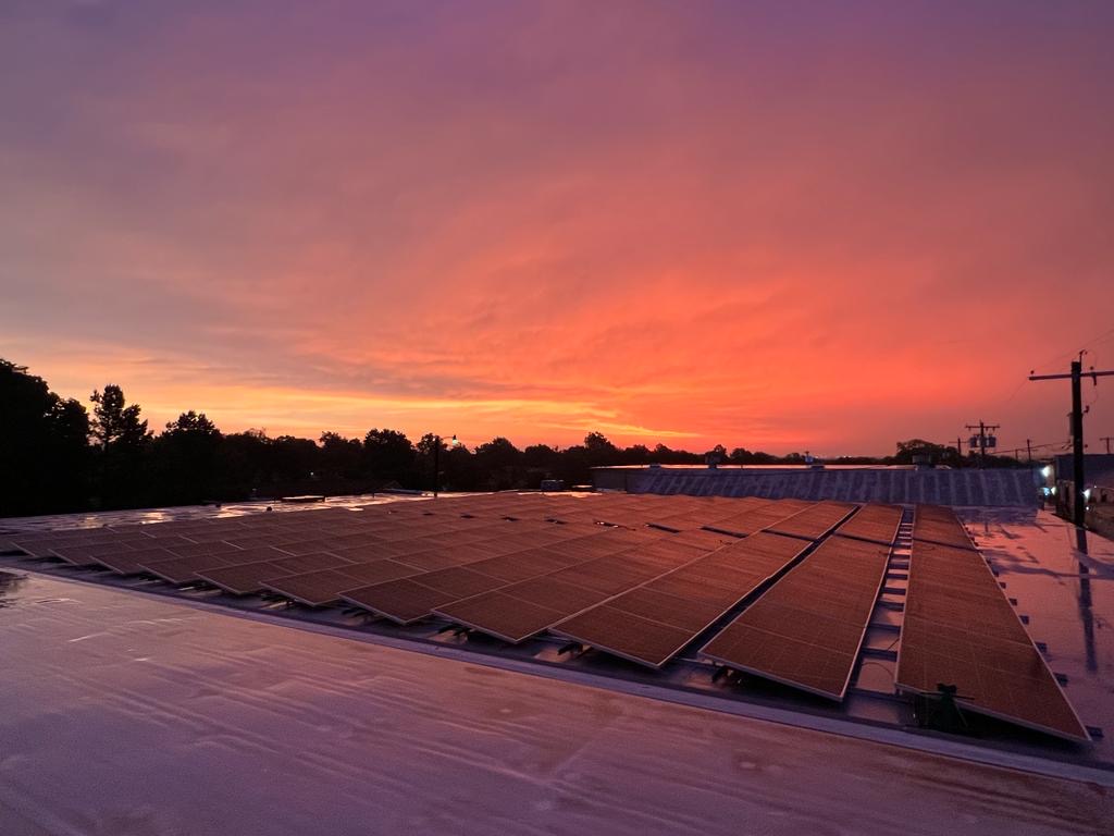 Commercial rooftop solar array at sunset on an Oklahoma facility